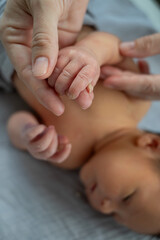 A newborn boy holds his mother's finger. Close-up of hands.