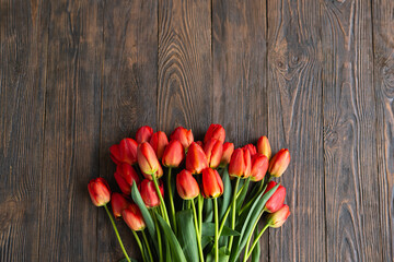 Fresh orange tulips on a wooden background. Springtime. Greeting card with copy space for Valentine's Day, Woman's Day and Mother's Day.