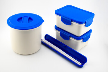 set of white plastic containers and food thermos with blue lid for lunch
