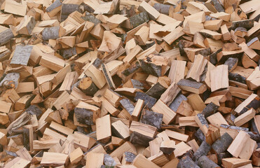 Firewood stacked near the wooden wall of old hut. Many chopped logs of firewood close up