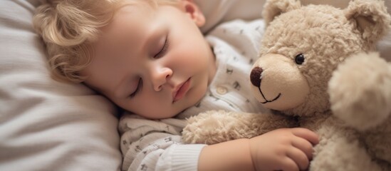 Cute child sleeping with teddy bear on bed at home