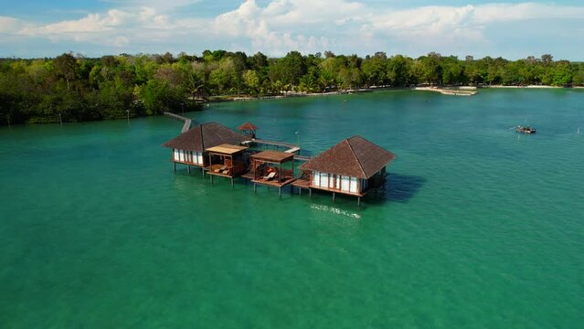 Overwater bungalow villa in the middle of the sea, drone flying down towards Leebong Island, Belitung, Indonesia