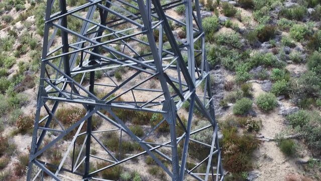 large 500kv electrical transmission utility tower with large string insulators on a hillside AERIAL TELEPHOTO RAISE
