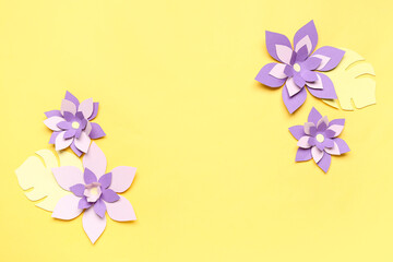 Colorful origami flowers with leaves on yellow background