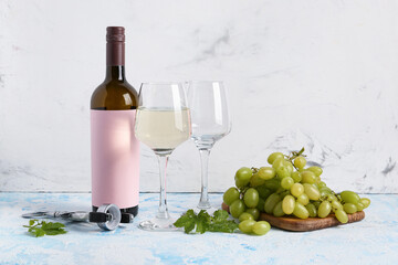 Fototapeta premium Bottle of wine with blank label and glasses on color background