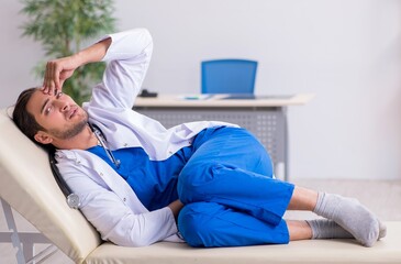 Young male doctor being tired after night shift