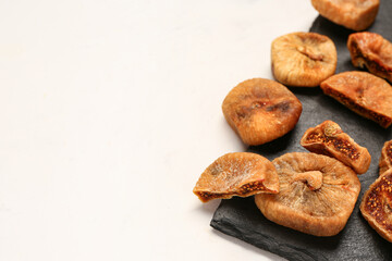 Board with sweet dried figs on white background