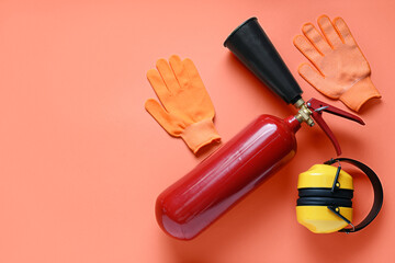 Fire extinguisher, hearing protectors and gloves on red background