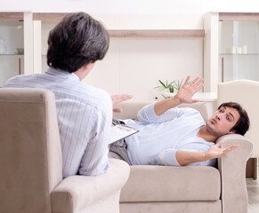 Young male patient discussing with psychologist personal problem