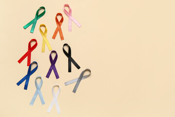 Different colorful ribbons on beige background. Cancer awareness concept