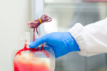 Red Blood bag with blue glove.