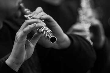  Hands of a musician playing the flute close-up in black and white