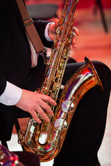 Saxophone in the hands of a musician - 727570806