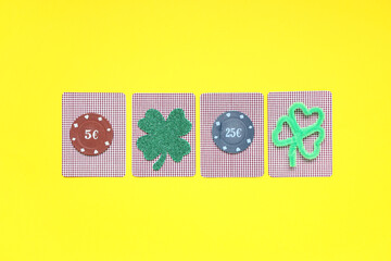 Cards with poker chips and lucky clovers on yellow background. St. Patrick's Day celebration