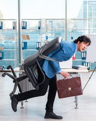 Chained male employee unhappy with excessive work
