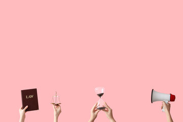 Female hands holding hourglass, law book, scales of justice and megaphone on pink background