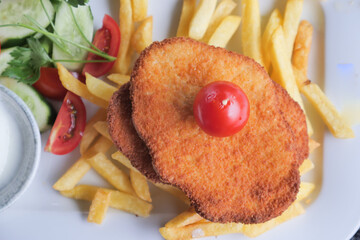 top view of Chicken schnitzel served with potato chips 