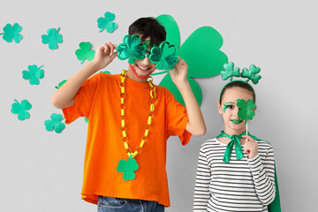 Funny kids with face paintings and clovers near white wall. St. Patrick's Day celebration