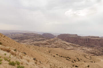 View from distance from high hill to the famous gorge in which it is located thr Nabatean Kingdom of Petra in the Wadi Musa city in Jordan