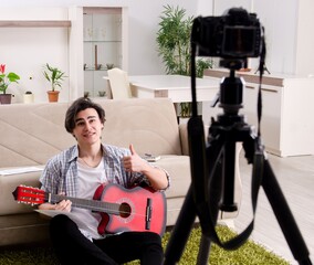 Young guitar player recording video for his blog