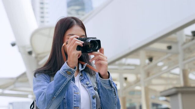 Young asian woman smiling and looking around, tourist female using taking travel picture with camera