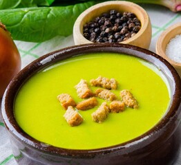 The spinach soup served on wooden board