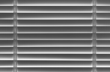 Obraz premium closed white venetian blinds curtain on window and morning to block light for dark or hidden keep secretly and afraid for modern room or home office decor with texture lines and pattern background