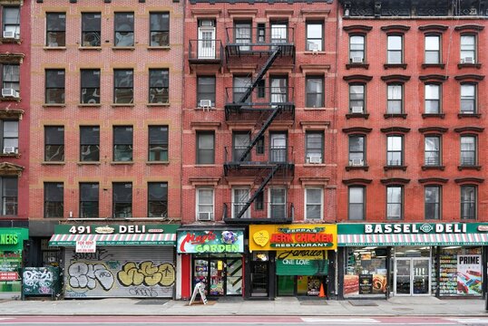 New York City old fashioned apartment buildings with external fire ladders and stores on ground floor