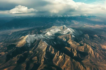  Mountains are covered in snow and are seen from an airplane © Roman