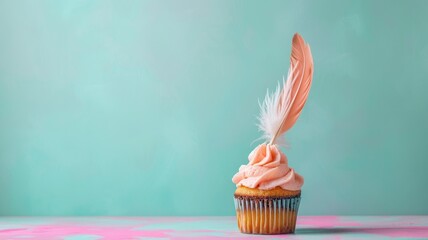 A single cupcake topped with a light pink frosting and a decorative feather