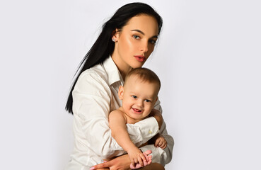 Mother hug. Closeup studio portrait of mother and baby child isolated on whtite. Mother hugging and embracing baby son. Mothers day, love family. Mother and baby child with tenderness.
