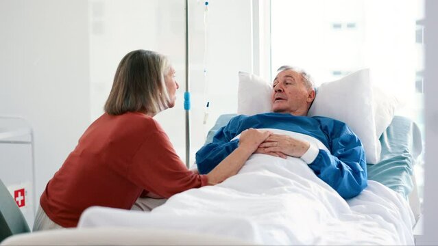 Senior woman, comfort and husband in hospital bed with cancer, illness or sick with chat for support. Elderly patient, man and couple with talk, empathy and love in retirement with memory in clinic