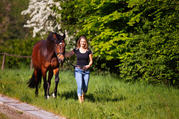 Young woman with horse in spring in nature.