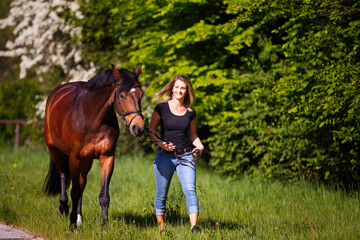 Young woman with horse in spring in nature.