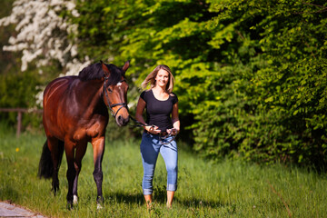 Young woman with horse in spring in nature.