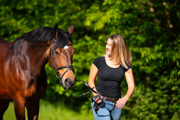 Young woman with horse in spring in nature.