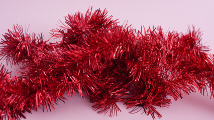 Red tinsel on pink background
