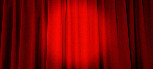 close up view of dark red curtain in thin and thick vertical folds made of black out sackcloth fabric, panoramic view. red curtain background with spotlight at center in theater or cinema.