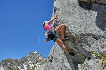 Frau am Berg beim Klettern, Bergsteigen an Felswand in den Alpen