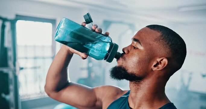 Gym, drinking water and black man with fitness, exercise and hydration with workout or training. African person, guy or athlete with wellness or health with liquid, strong or endurance with nutrition