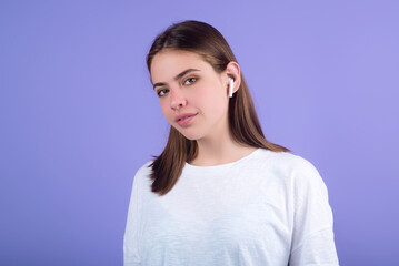 Woman listening to music with earphones. Girl with headphones, wireless earphones. Listening music in earphone, studio. Earphones in ear. Woman using headphones. Ear buds, wireless earbud earphone.