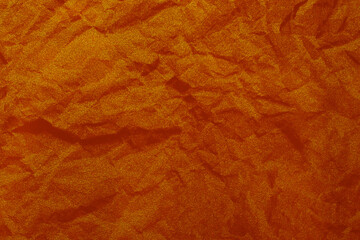 Background with crumpled, battered, red orange fabric material with copy space.Empty blank backdrop