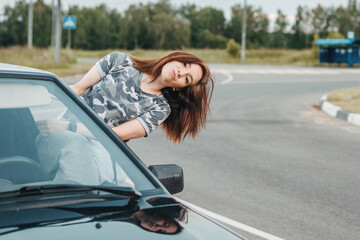 pretty girl sticks out of the car window. sexy girl and car. young car driver. girl smiling from car