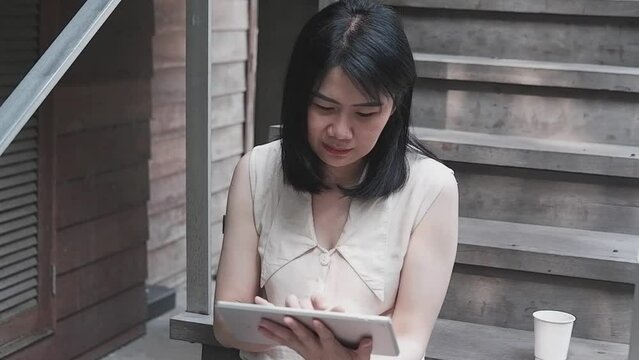 Smiling Asian woman is working and online shopping for successful with tablet. Technology with businesswoman