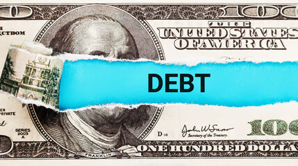 Debt. The word Debt in the background of the US dollar. Financial Burden, Loan, and Credit Concept. Stress from Financial Obligations. - obrazy, fototapety, plakaty