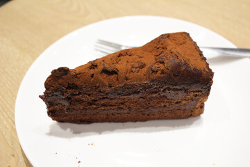 A Dark chocolate cake at white plate