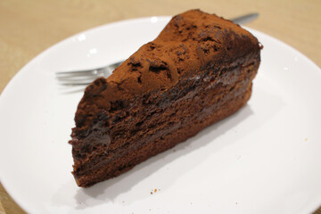 A Dark chocolate cake at white plate