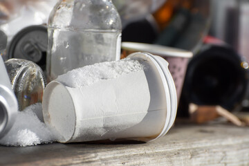 A pile of garbage: paper cups, empty bottles, plastic. Close-up photo.