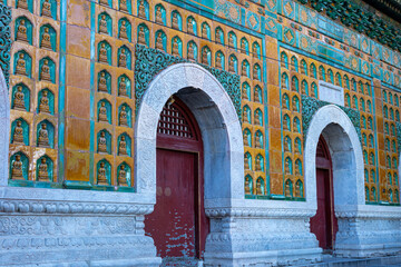 Artistically adorned wall of an ancient palace section in China with neatly arranged carvings and...
