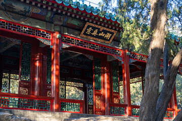 A large Chinese gazebo structure with open doors and windows, adorned with dense sculptures and ornaments surrounding a Chinese writing that translates " The Lake of Yizhenshan."